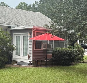 A house with a covered patio, a door, and a window. - Downtown Aiken Enjoyable 3-bedroom house-walking distance to downtown (Aiken)