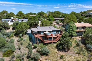 A residential property with a large deck, surrounded by trees and other houses. - Pine Nest Retreat Scenic Views and Private Saloon (Prescott)