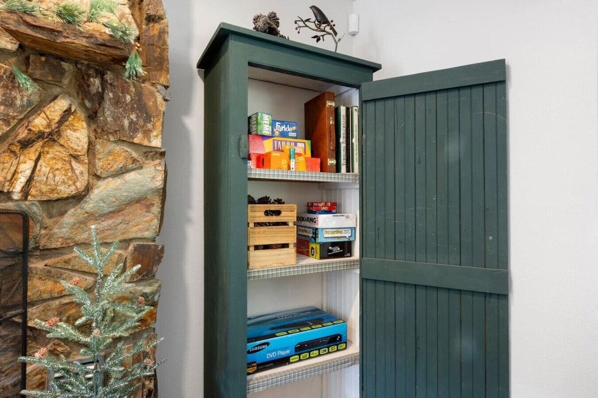 A bookshelf with various items including books, DVDs, and decorative objects.