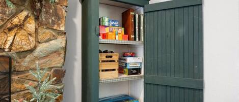A bookshelf with various items including books, DVDs, and decorative objects.