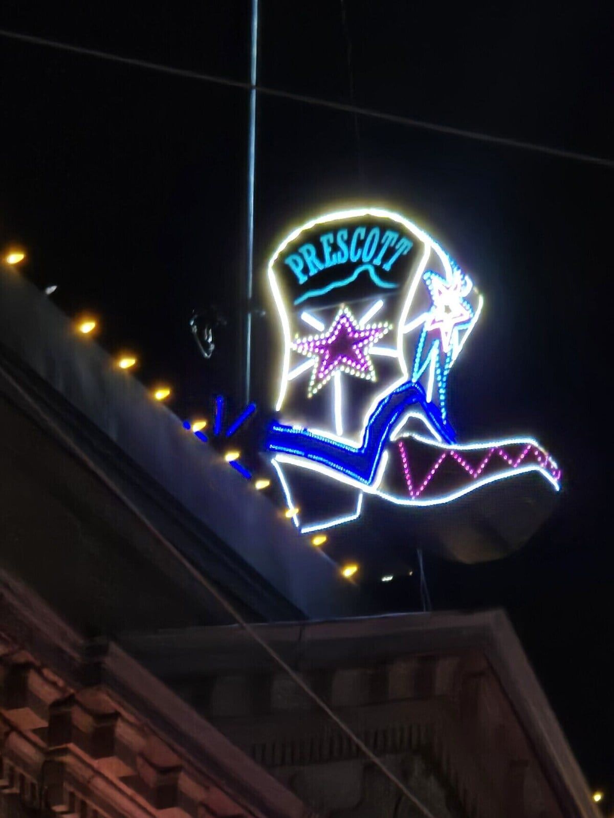 Une enseigne au néon avec le mot « PRESCOTT » et un motif en forme d’étoile.