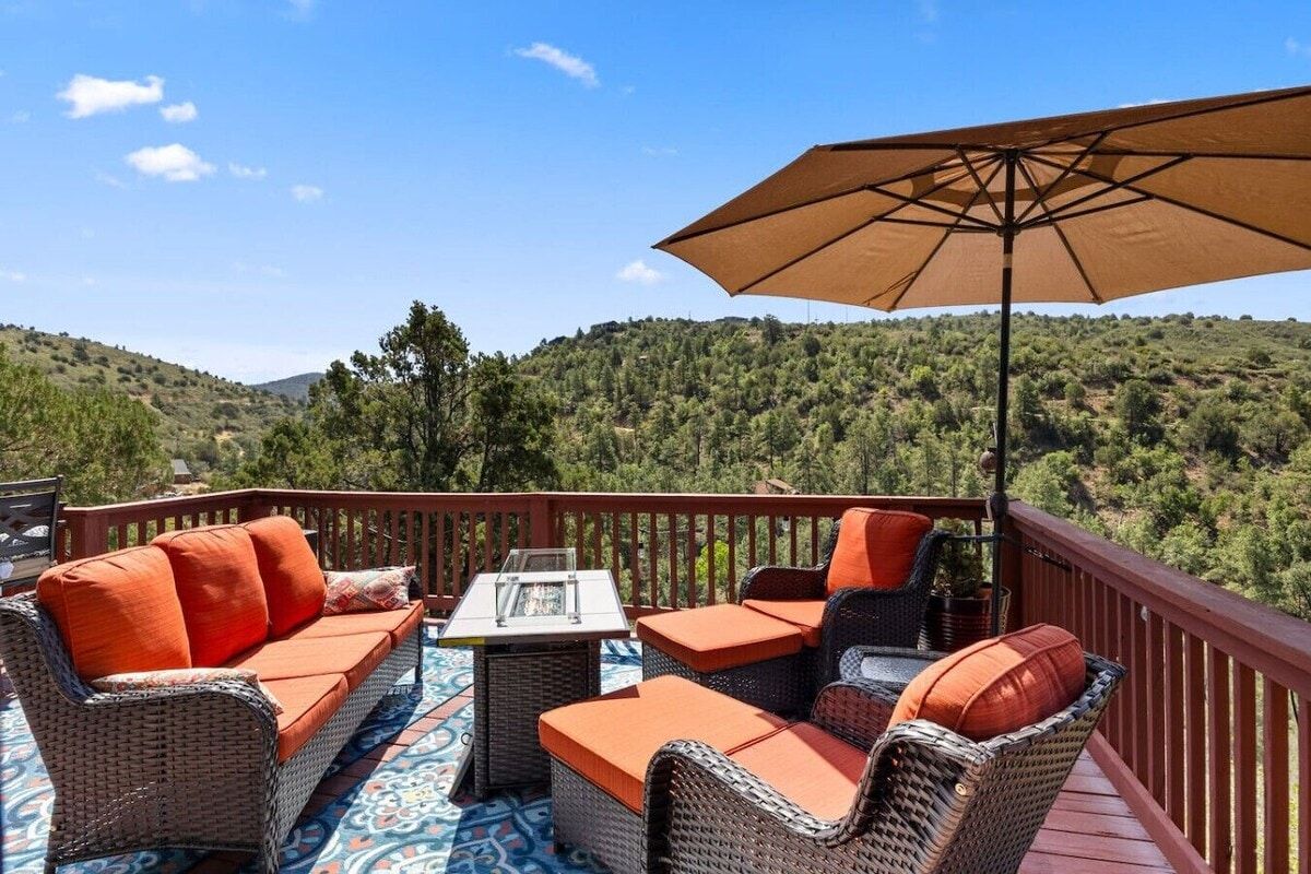 Une terrasse extérieure avec des meubles en osier, une table et un parasol.