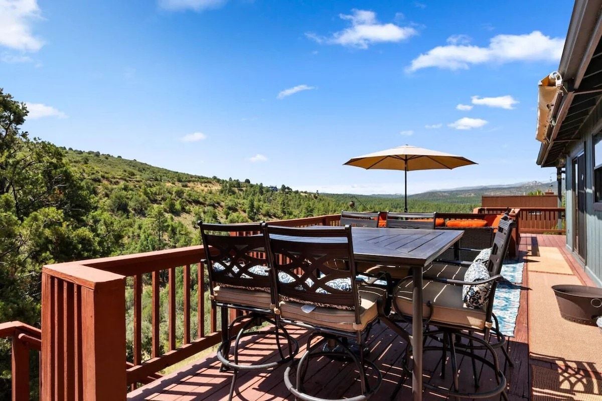Une terrasse dotée de mobilier d’extérieur, d’une table et d’un parasol.