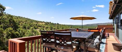 Une terrasse dotée de mobilier d’extérieur, d’une table et d’un parasol.