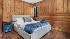 A bedroom with a bed, a nightstand, and a window. - Once Upon A Blue Pine (Idyllwild-Pine Cove)