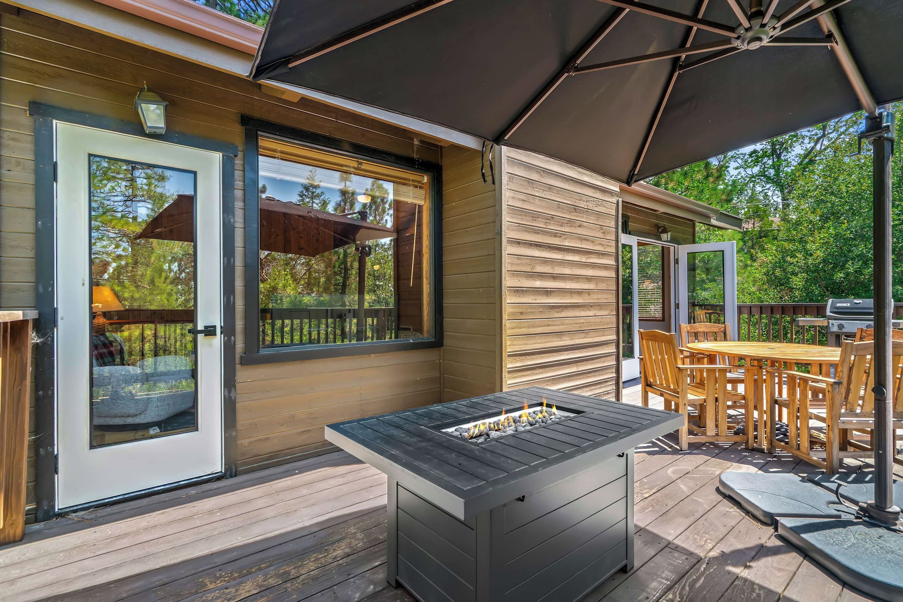 Eine Terrassenausstattung mit Grill, Tisch und Stühlen.