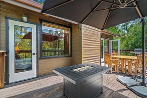 Eine Terrassenausstattung mit Grill, Tisch und Stühlen.