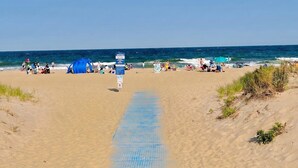 A beach with a clear path leading to the water, people relaxing, and a blue tent. - 3 Bedroom Argyle Mermaid by the sea (Neptune Township)