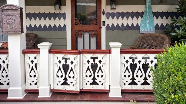 A wooden porch with a decorative door, a sign reading 'The Argyle Mermaid,' and a mermaid tail sign. - 3 Bedroom Argyle Mermaid by the sea (Neptune Township)