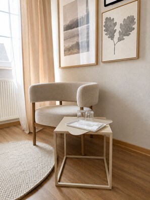 A modern room with a sofa, a small table with glasses and a tray, and framed artwork on the wall. - Landgasthof zum Löwen in Graben-Neudorf (Graben-Neudorf)