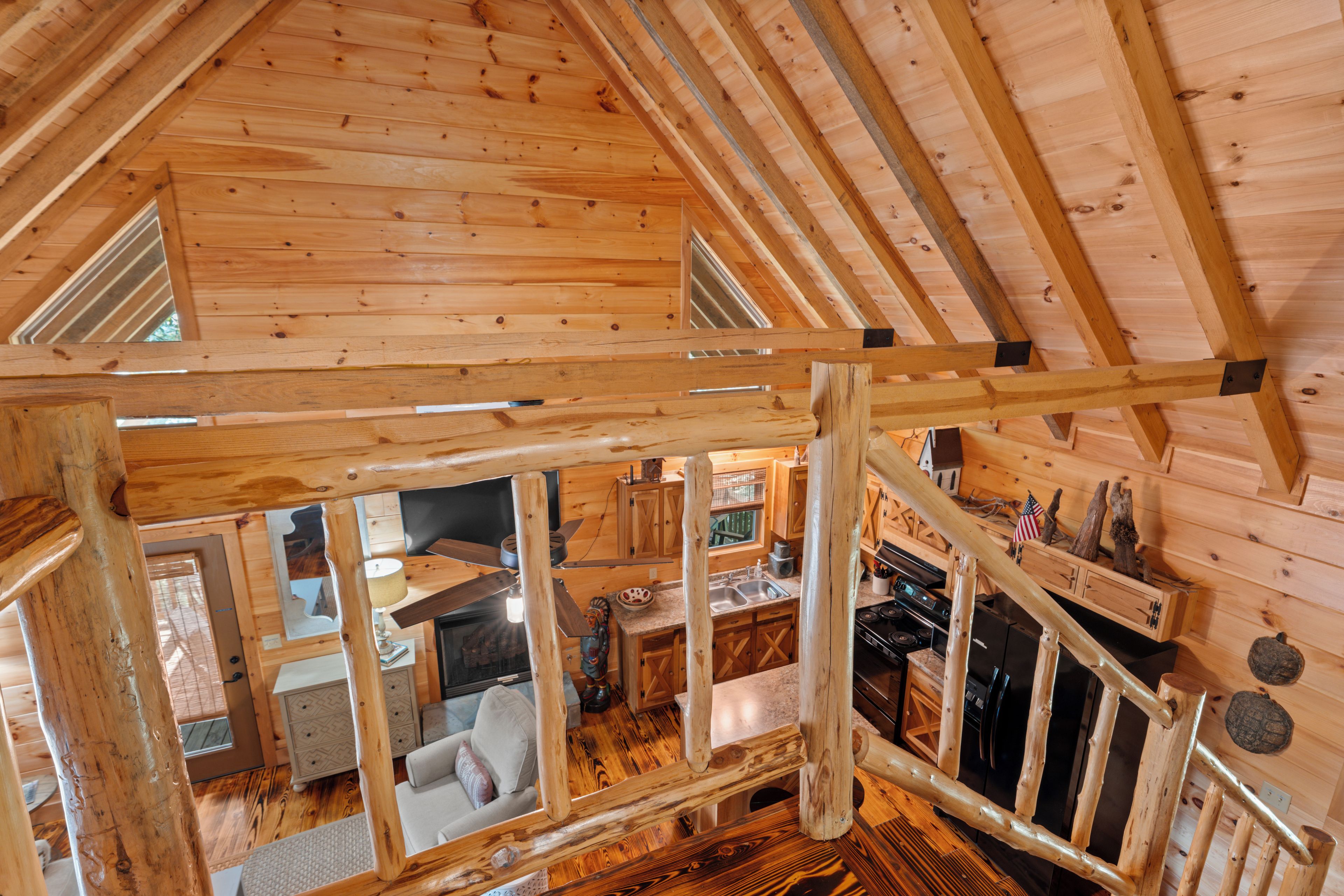 Ein Holzblockhaus mit Schlafzimmer auf dem Dachboden, Küche und Wohnbereich.