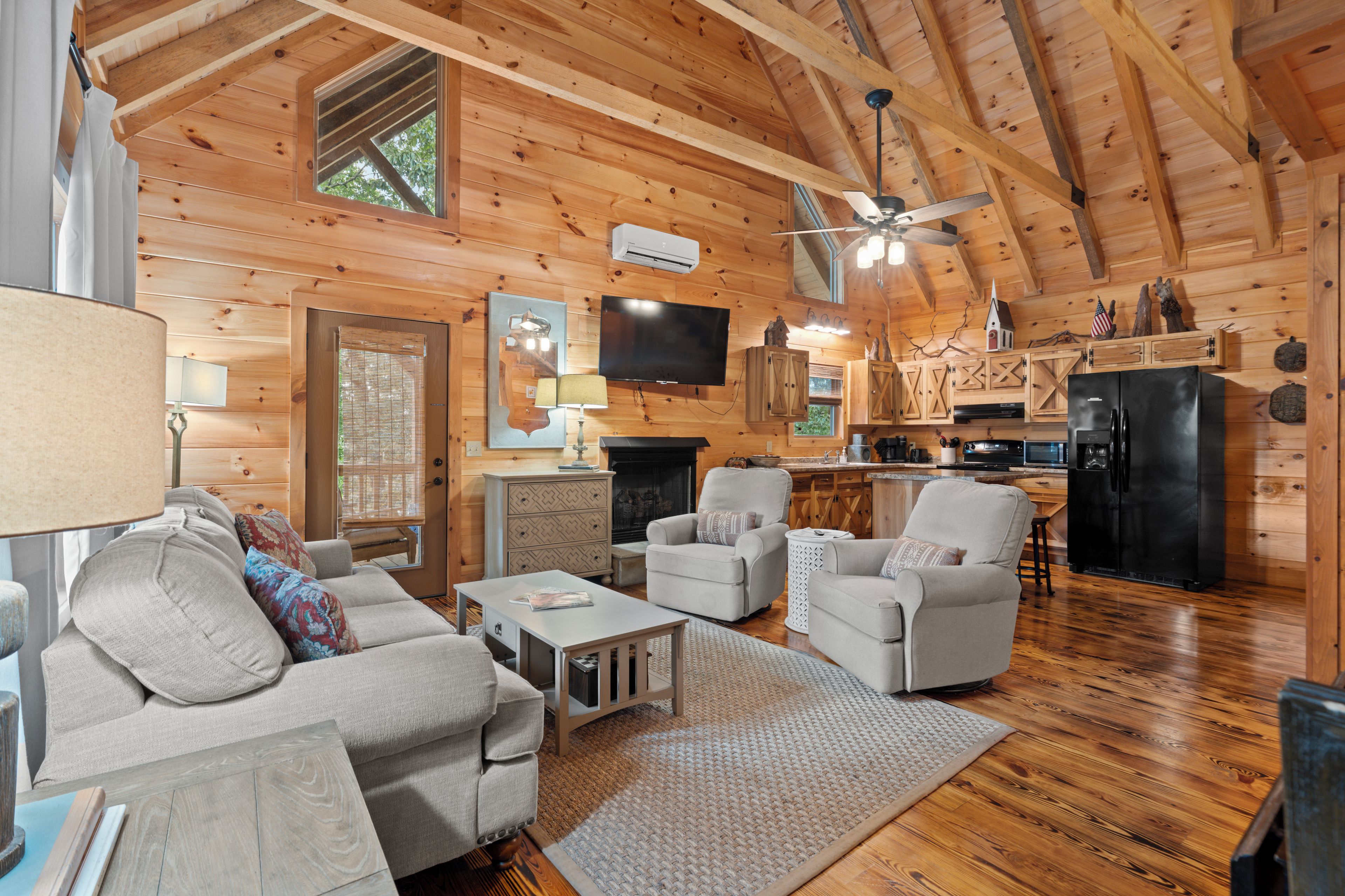 A cozy cabin interior with a living room, kitchen, and dining area.