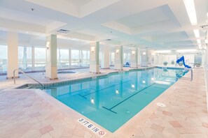 Piscina interior com água cristalina, chão ladrilhado e indicador de profundidade de 1,10 metros.
