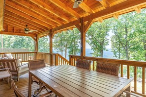 A wooden deck with a table and chairs, overlooking a forested area. - Pappy's Peace cozy cabin atop the Alabama Alps! (Mentone)