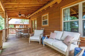 A wooden deck with a sofa and chairs, a table, and a ceiling fan. - Pappy's Peace cozy cabin atop the Alabama Alps! (Mentone)