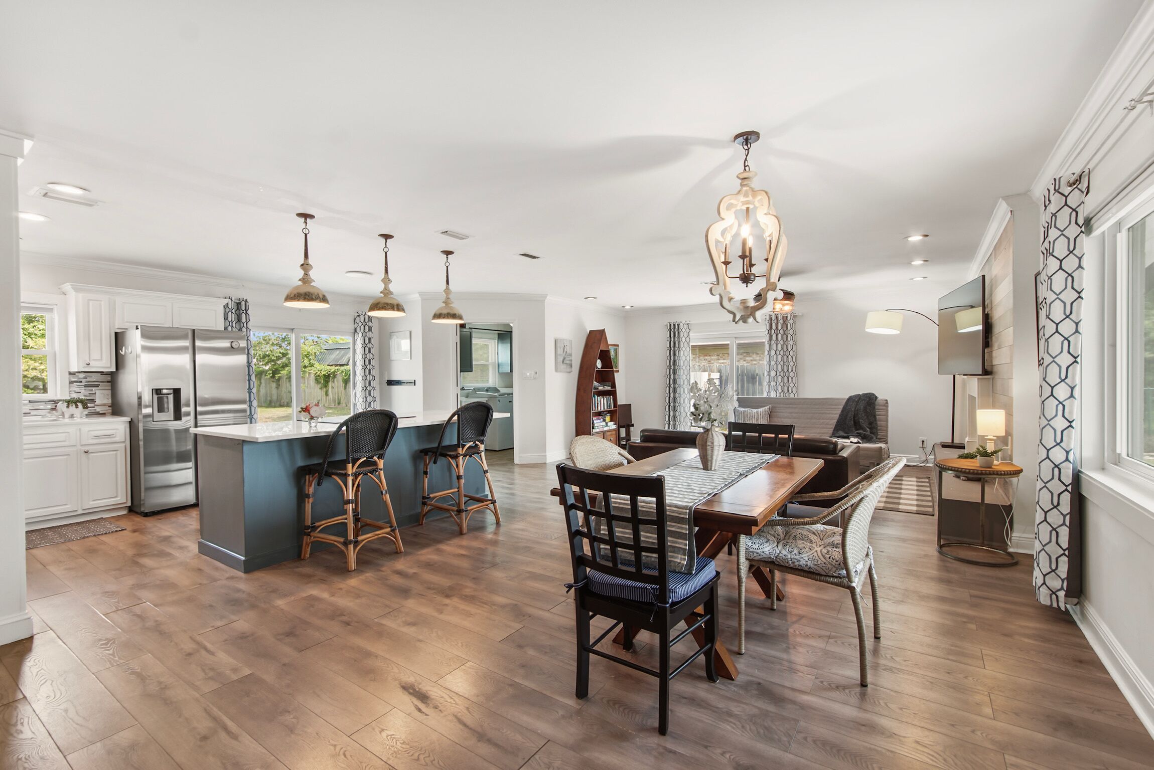 A spacious kitchen with a central island, bar stools, and pendant lighting.