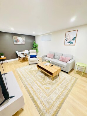Ein modernes Wohnzimmer mit einer Couch, einem Couchtisch und Sesseln.