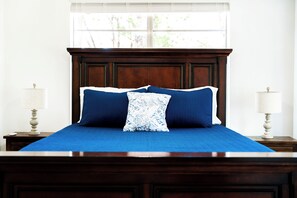 A bed with a dark headboard, two bedside lamps, and a window with blinds. - Canyon Lake Chalet - Firepit, Hot tub, Boat Parking (Canyon Lake)