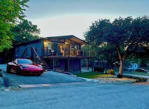 A modern two-story house with a red sports car parked in front. - Canyon Lake Chalet - Firepit, Hot tub, Boat Parking (Canyon Lake)
