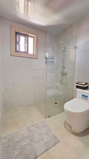 A bathroom with a glass-enclosed shower, a toilet, and a small window. - A magnificent oasis of peace just a few minutes from Bavaro Beach (Punta Cana)