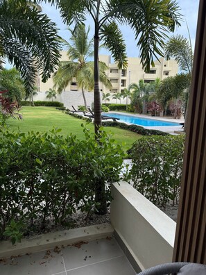 A view of a swimming pool surrounded by greenery and a building in the background. - A magnificent oasis of peace just a few minutes from Bavaro Beach (Punta Cana)
