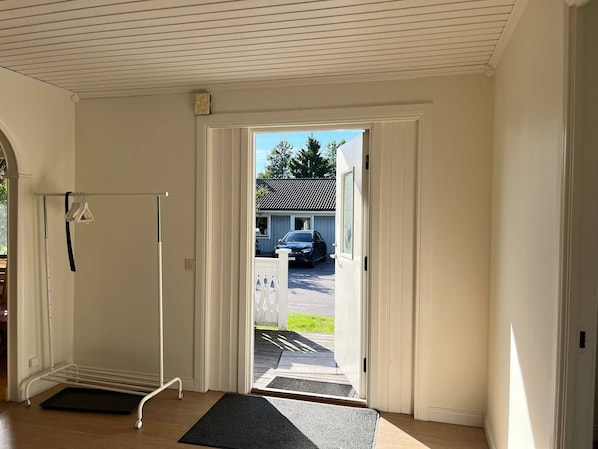 A room with a door leading outside, a coat rack, and a mat at the entrance. - Room-room 3 in Vålberg, Karlstad (Vålberg)