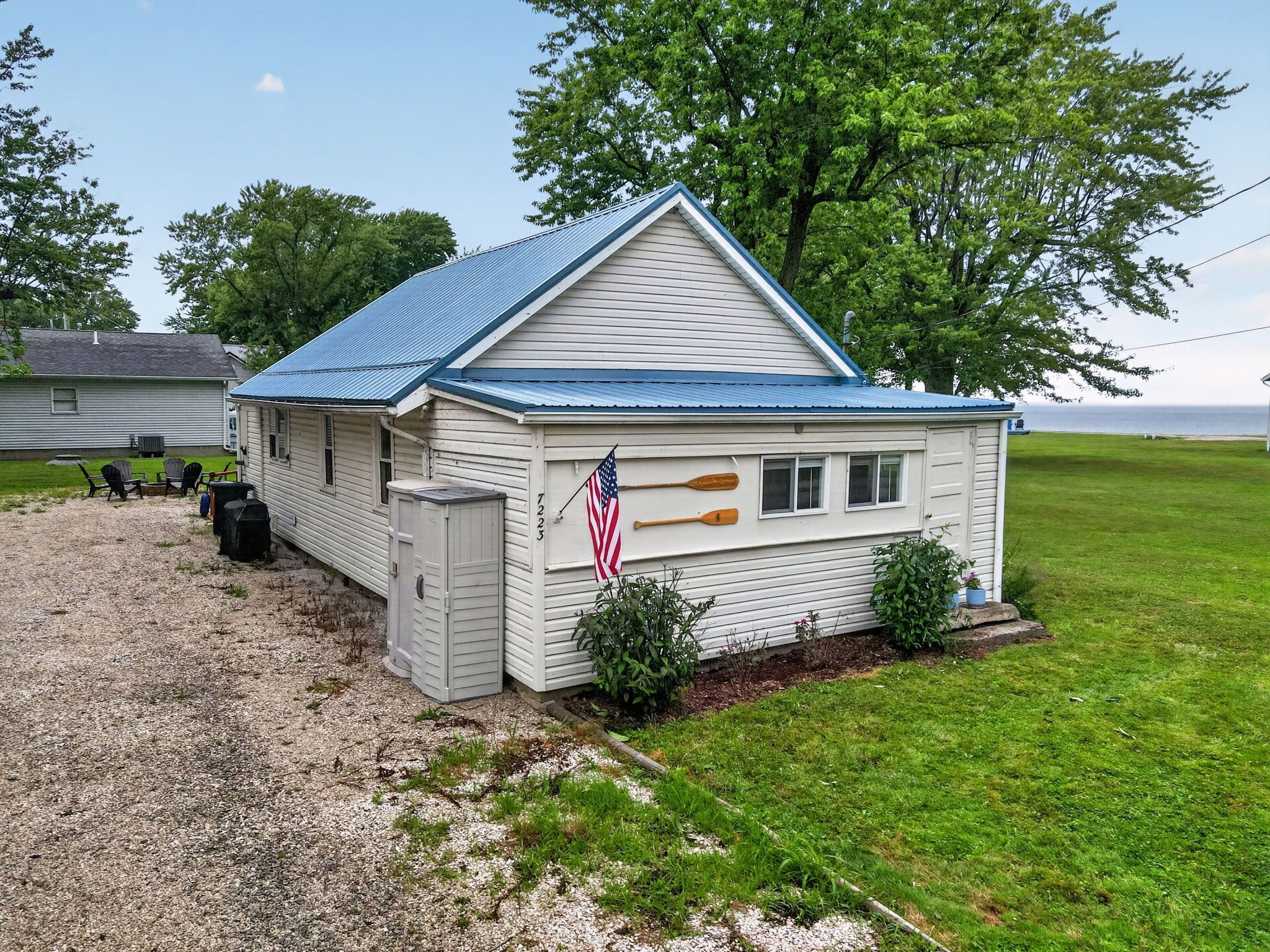 A small, single-story building with a blue roof, a flag, and a paddle.