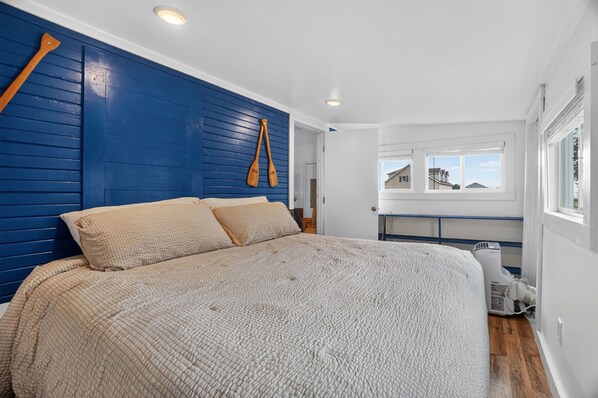 Un dormitorio con una cama grande, paneles de madera y una ventana con vistas.
