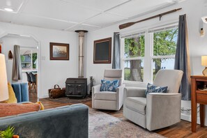 Een gezellige woonkamer met een open haard, comfortabele zitplaatsen en uitzicht op de omgeving.