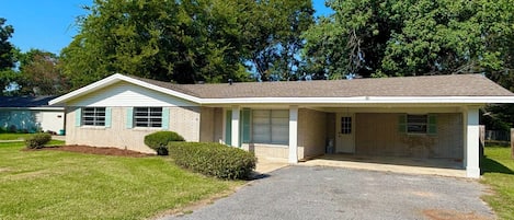 A single-story house with a front garage, a covered porch, and a well-maintained lawn.