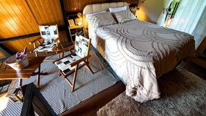 Un dormitorio con una cama grande, muebles de madera y vistas al exterior.
