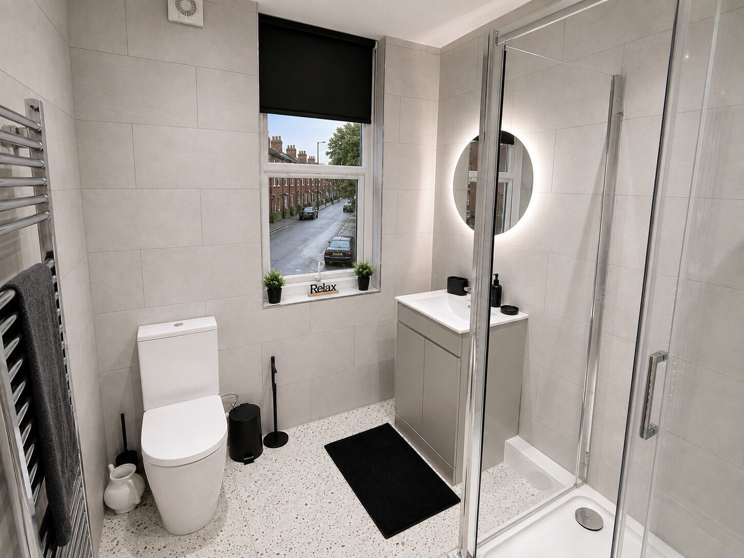 Een moderne badkamer met toilet, wastafel en douche.