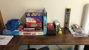 Un escritorio con varios juegos de mesa y un cuadro en la pared.