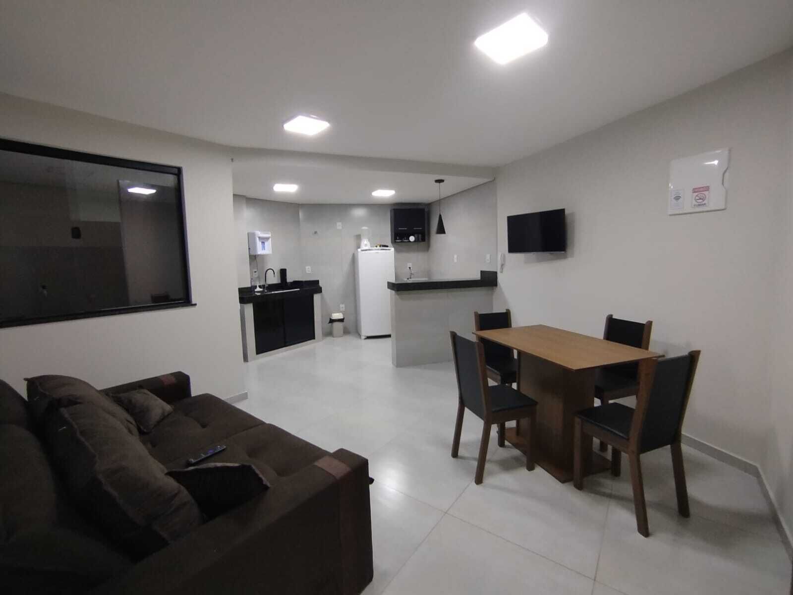 Un espacio habitable compacto con kitchenette, zona de comedor y zona de estar.