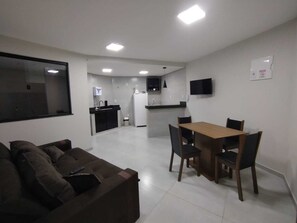 A compact living space with a kitchenette, a dining area, and a seating area.