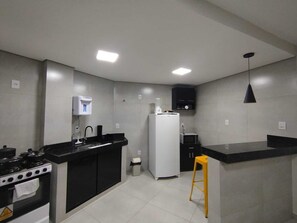 Eine moderne Küche mit Herd, Spüle, Kühlschrank und einer Theke.