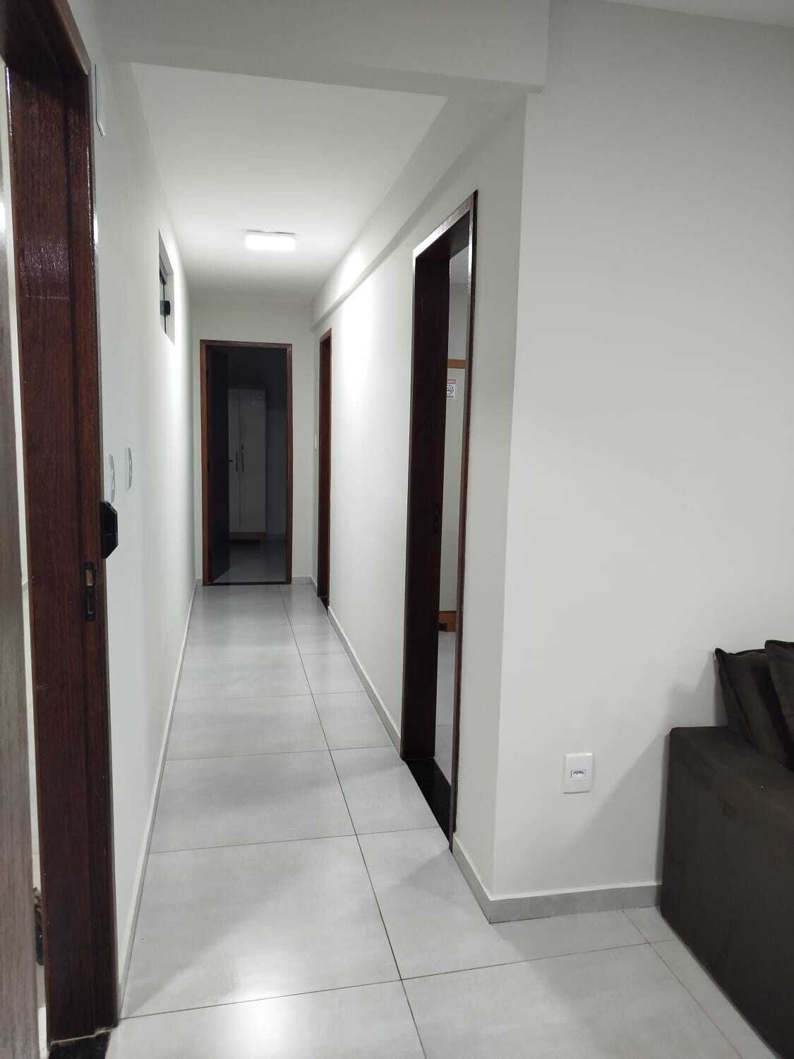 Un pasillo con piso de baldosas que conduce a una puerta al final.
