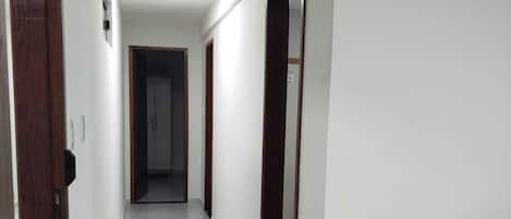 Un pasillo con piso de baldosas que conduce a una puerta al final.