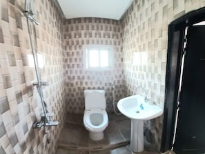 A bathroom with a toilet, a sink, and a shower.