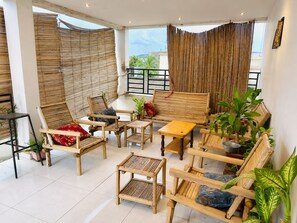 A room with a balcony, bamboo blinds, and various seating arrangements including chairs and a sofa. - Room-beautiful Private Room With Private (Bamako)