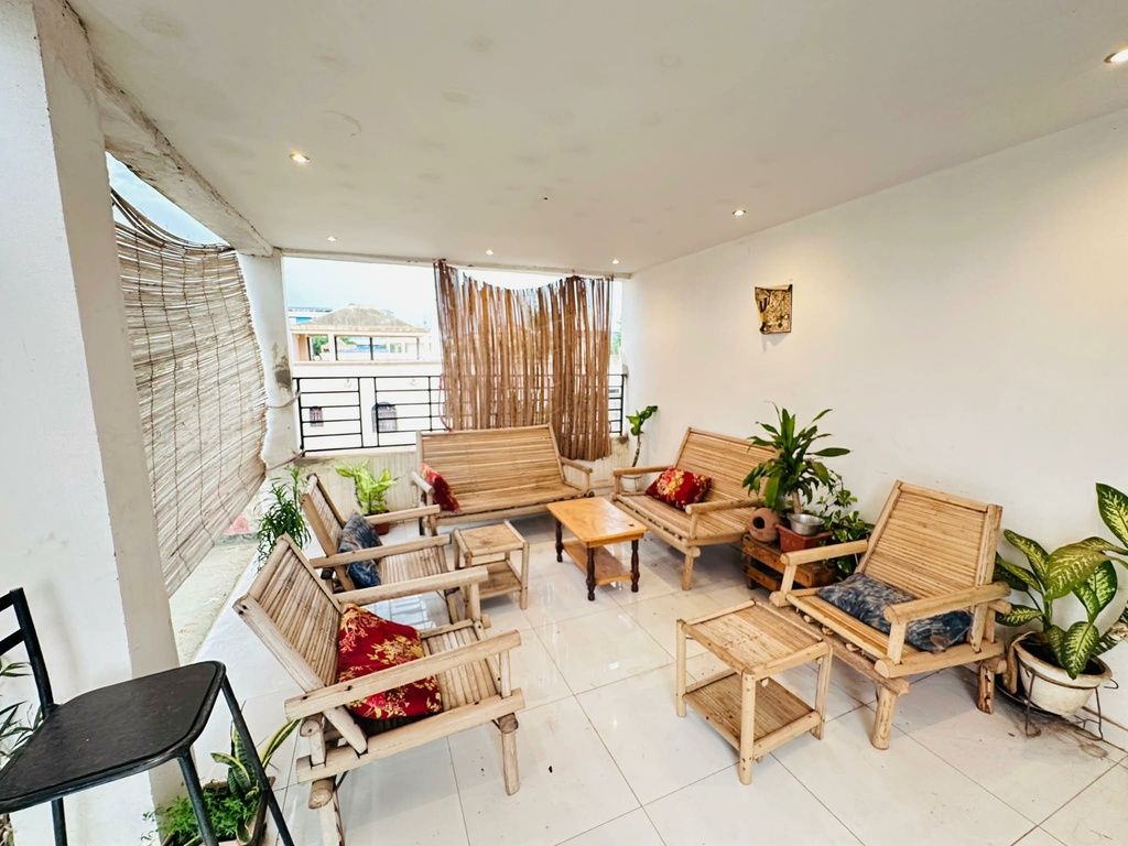 Een ruime woonkamer met verschillende houten meubelstukken, waaronder banken en stoelen, gerangschikt rond een bijzettafeltje.