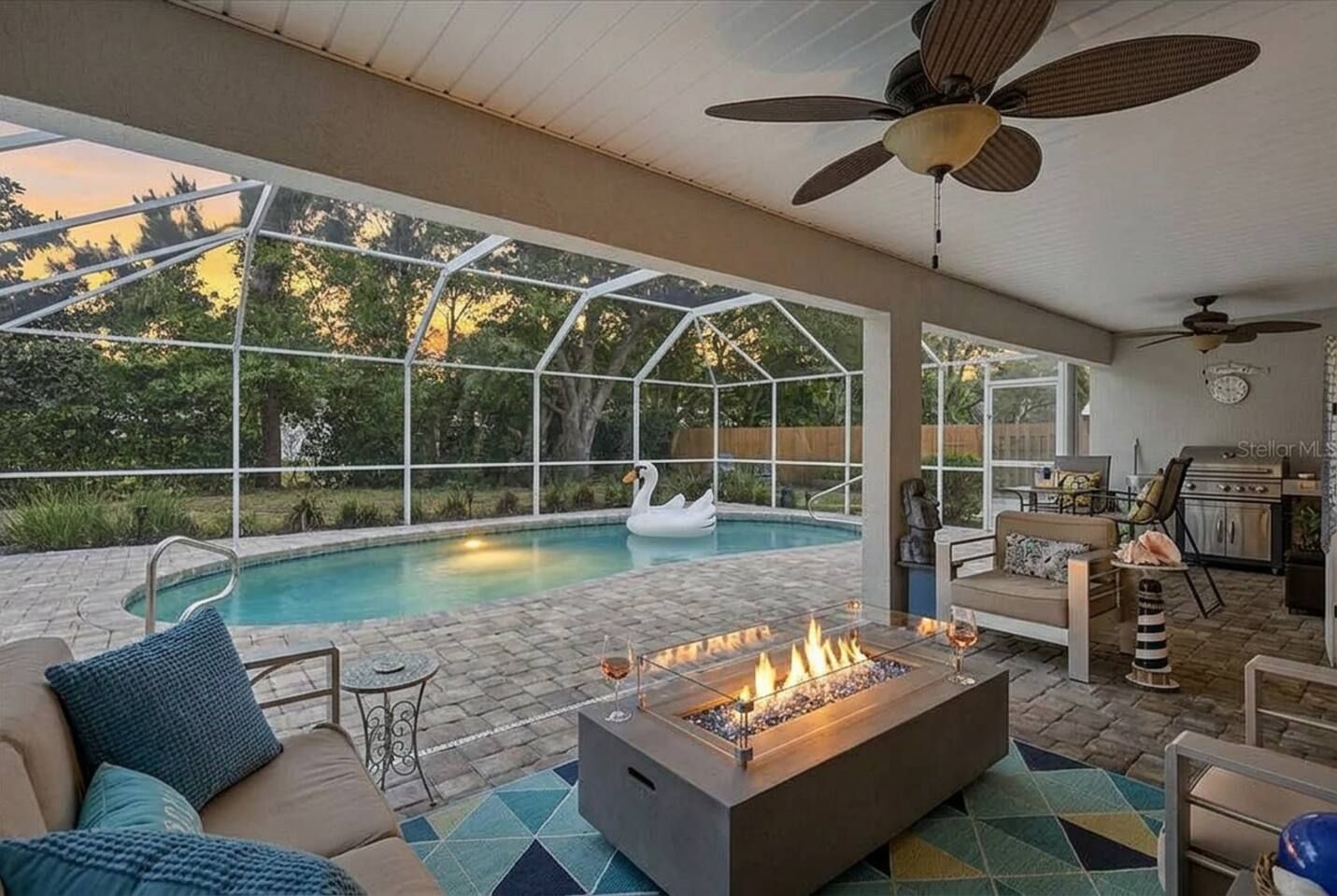 A pool area with a swan float, a fire pit, and outdoor furniture.