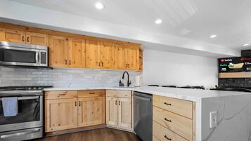 Una cocina moderna con armarios de madera, electrodomésticos de acero inoxidable y una encimera de mármol.