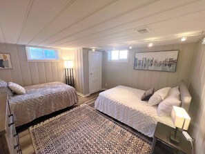A hotel room with two beds, a large window, a cityscape painting, and a floor lamp. - Spacious Retreat: Walk to Midtown Near Dining+Fun (Reno)