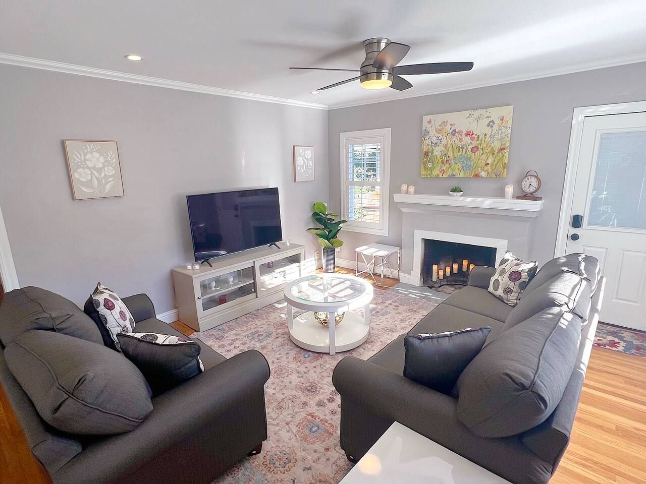 Ein Wohnzimmer mit Flachbildfernseher, zwei Sofas, einem Couchtisch und einem Kamin.