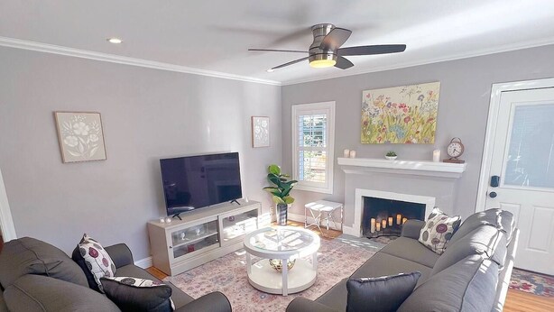 Una sala de estar con televisor de pantalla plana, dos sofás, una mesa de centro y una chimenea.