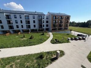 Ein modernes Gebäude mit mehreren Balkonen und einem gepflasterten Innenhof.