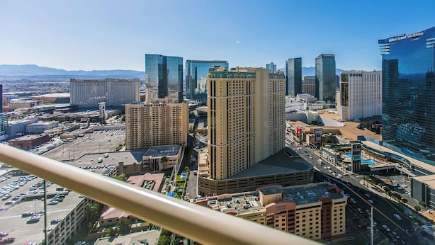 Un paisaje urbano con edificios modernos y altos, incluyendo un hotel destacado con un letrero visible.