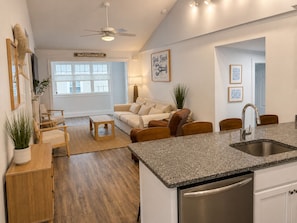 A modern kitchen with a granite countertop, stainless steel sink, and a dishwasher.