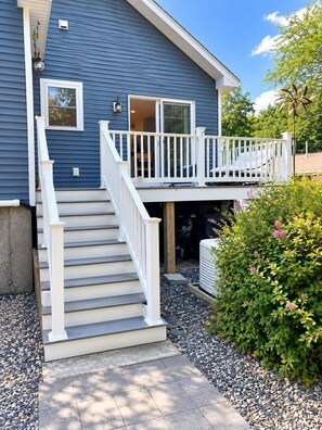 A two-story house with a white staircase leading to a balcony.
